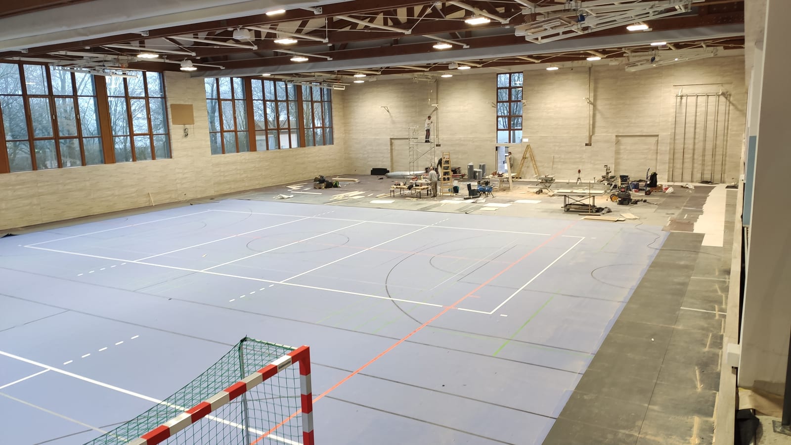 Sporthalle während der Montage: Wandverkleidung, Sportboden und Einbauelemente
